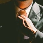 man touching tie