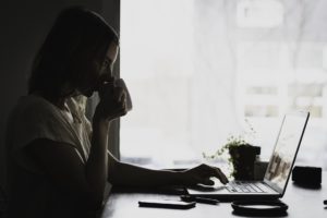 woman drinking in front of PC